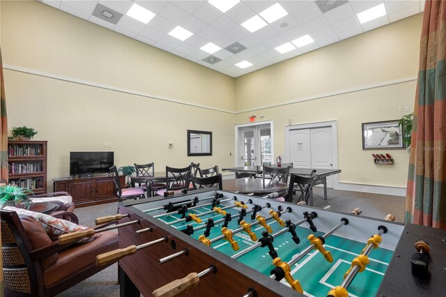 recreation room with a high ceiling, carpet floors, french doors, and a paneled ceiling