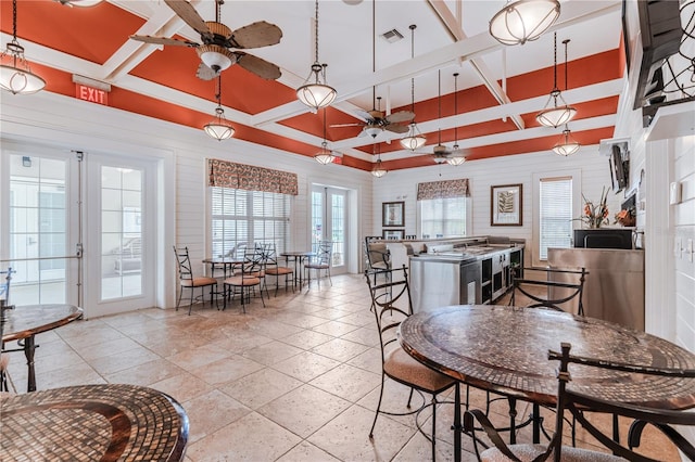 dining room with ceiling fan, beamed ceiling, and french doors