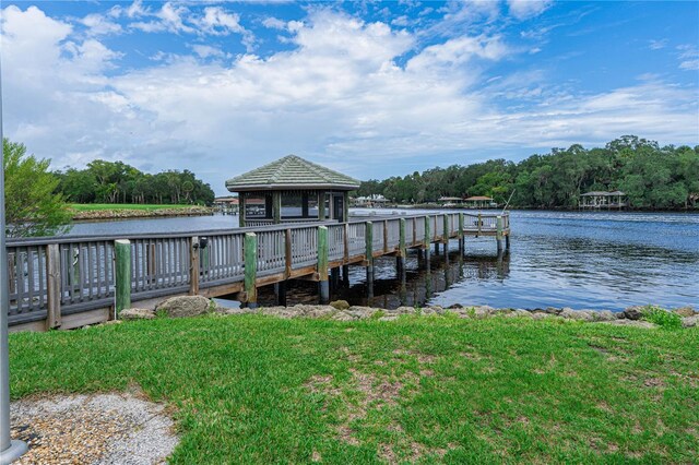 view of dock featuring a water view, a gazebo, and a yard