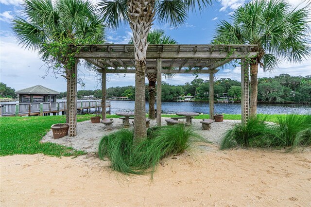 surrounding community with a pergola, a water view, a gazebo, and an outdoor fire pit