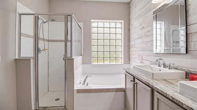 bathroom with vanity, plus walk in shower, and a healthy amount of sunlight