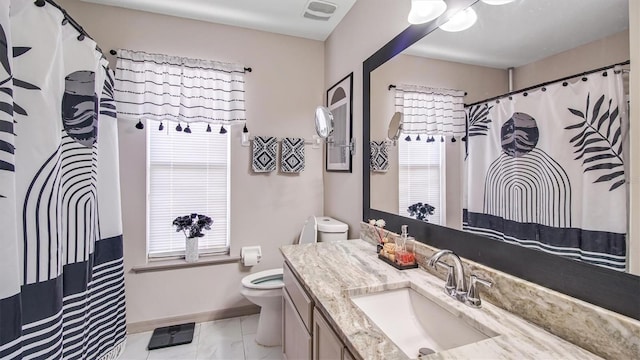 bathroom featuring plenty of natural light, vanity, and toilet