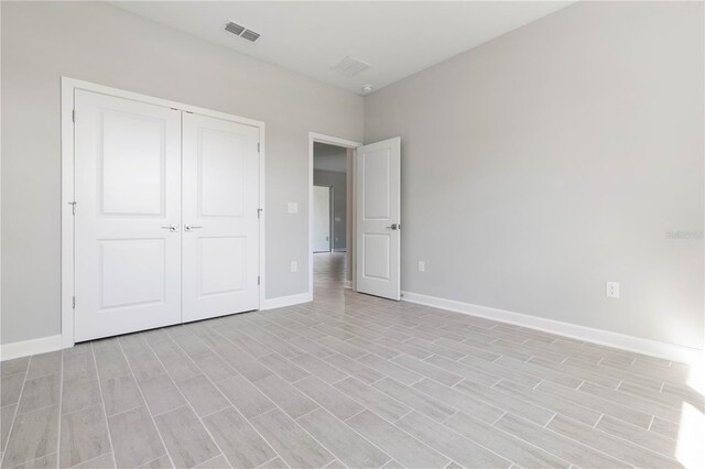 unfurnished bedroom with light hardwood / wood-style flooring and a closet