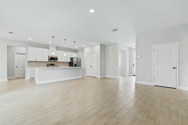 unfurnished living room featuring light hardwood / wood-style flooring and sink