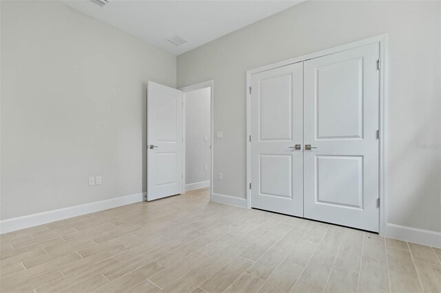 unfurnished bedroom with light hardwood / wood-style flooring and a closet