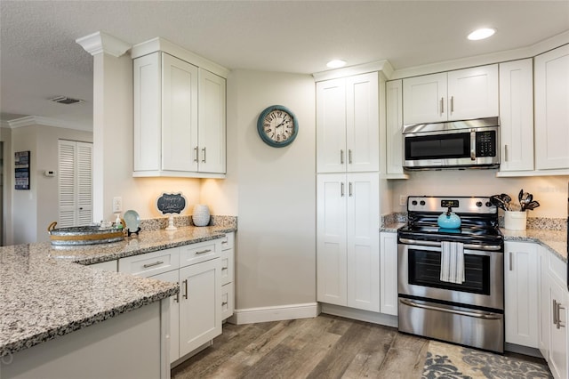 kitchen with light hardwood / wood-style flooring, stainless steel appliances, and white cabinetry