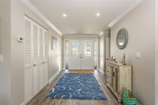 foyer with ornamental molding and hardwood / wood-style floors