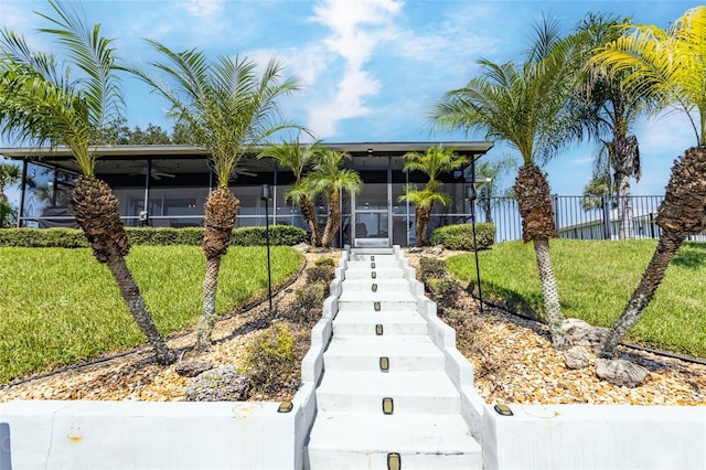 view of front of property featuring a sunroom and a front yard