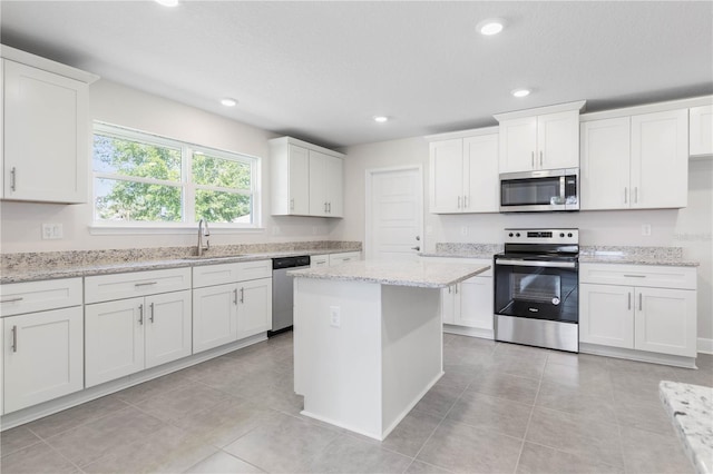 kitchen featuring white cabinets, appliances with stainless steel finishes, sink, and light stone countertops