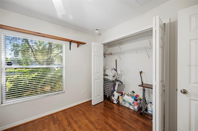 bedroom with multiple windows, a closet, dark wood-type flooring, and ceiling fan