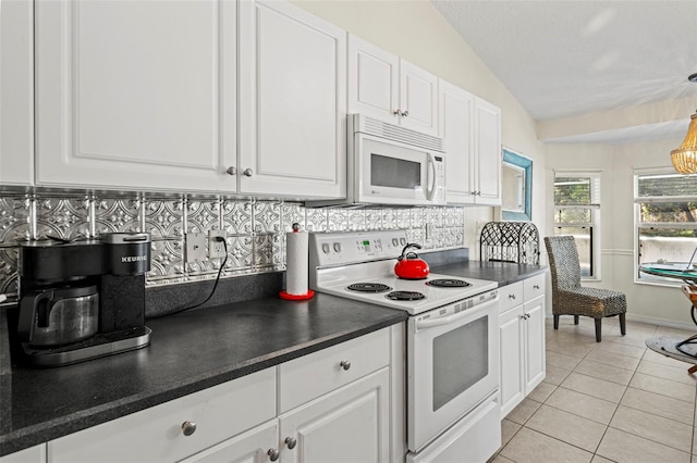 kitchen featuring white appliances, tasteful backsplash, white cabinetry, vaulted ceiling, and light tile patterned floors