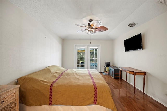 bedroom featuring hardwood / wood-style floors, ceiling fan, a textured ceiling, access to exterior, and french doors