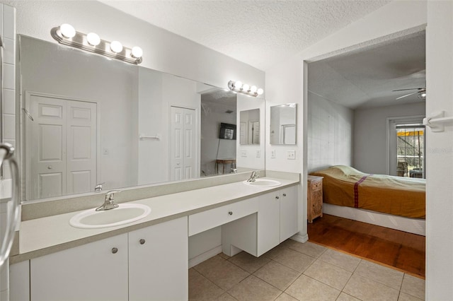 bathroom featuring vanity, ceiling fan, a textured ceiling, and tile patterned flooring