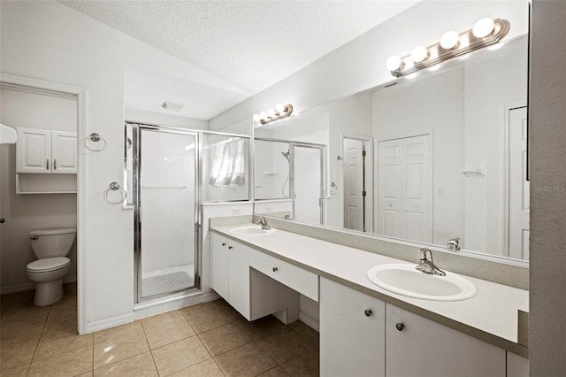 bathroom with vanity, a textured ceiling, walk in shower, and toilet