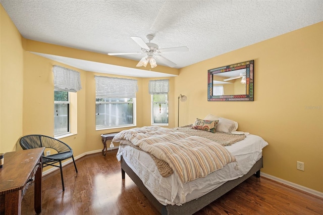 bedroom featuring ceiling fan, a textured ceiling, and dark hardwood / wood-style floors