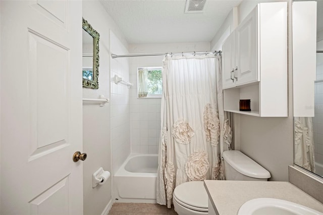 full bathroom featuring a textured ceiling, shower / bathtub combination with curtain, toilet, vanity, and tile patterned floors