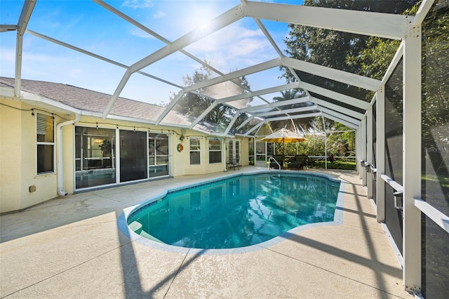 view of swimming pool featuring a patio area and glass enclosure