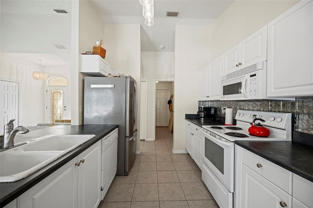 122 Lindsay Dr, Palm Coast, FL 32137 - kitchen featuring white appliances, dark countertops, white cabinetry, and a textured ceiling