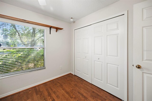 122 Lindsay Dr, Palm Coast, FL 32137 - unfurnished bedroom featuring a closet, dark wood-type flooring, ceiling fan, and a textured ceiling