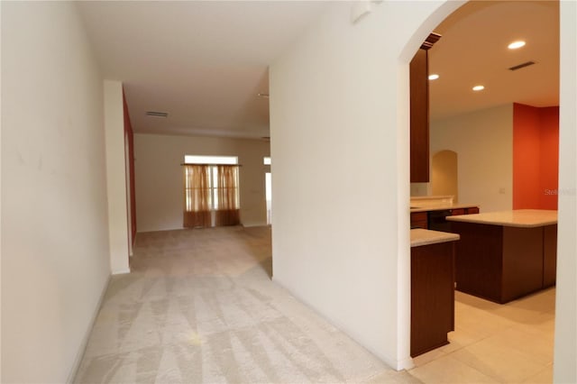 corridor featuring recessed lighting, visible vents, arched walkways, and light carpet