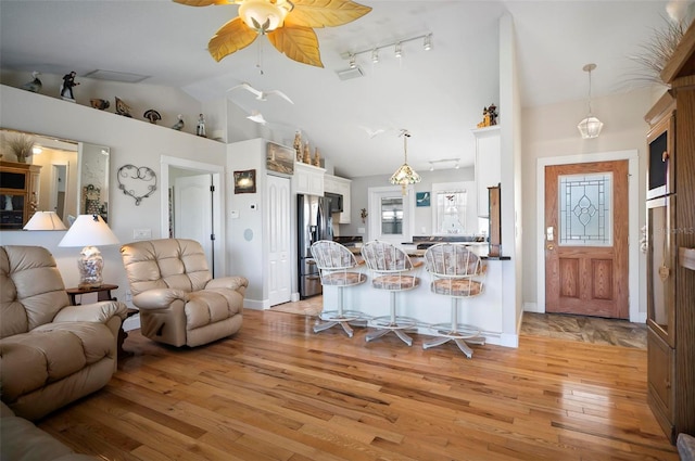 living room with ceiling fan, light hardwood / wood-style flooring, and high vaulted ceiling