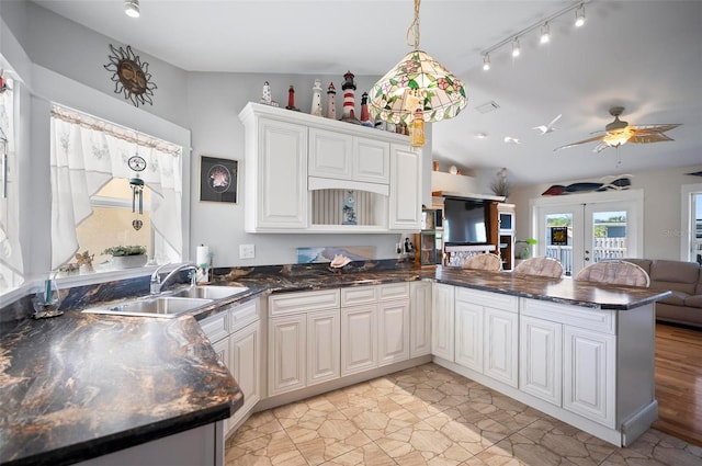 kitchen featuring kitchen peninsula, white cabinetry, sink, and french doors