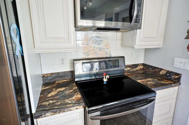 kitchen featuring dark stone counters, tasteful backsplash, stainless steel appliances, and white cabinets