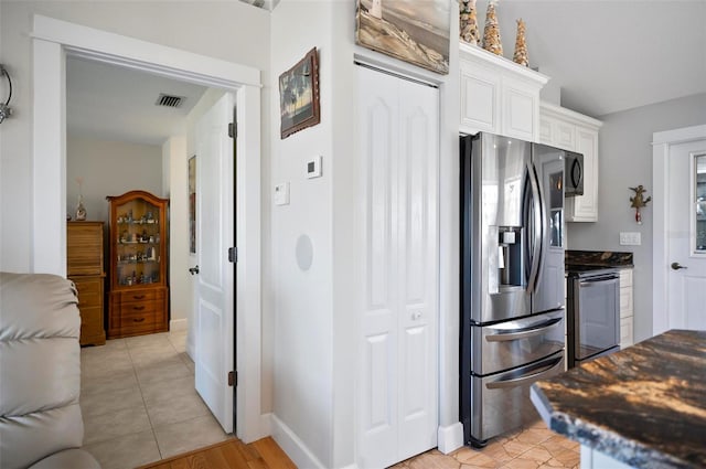 kitchen with white cabinets, appliances with stainless steel finishes, and light tile patterned floors