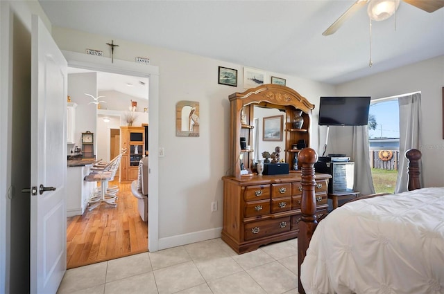 bedroom with ceiling fan, light tile patterned flooring, and vaulted ceiling