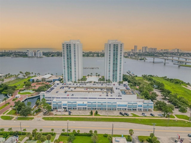 aerial view at dusk featuring a water view