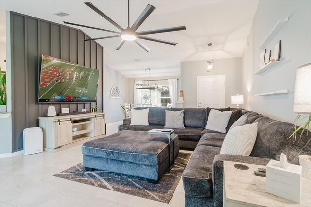 living room with ceiling fan with notable chandelier and vaulted ceiling