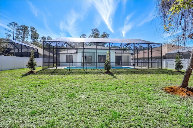 back of house featuring a fenced in pool, a lanai, a fenced backyard, and a yard