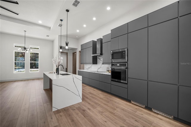 kitchen featuring wall chimney exhaust hood, stainless steel microwave, modern cabinets, and wall oven