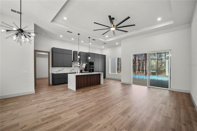 kitchen featuring open floor plan, light countertops, modern cabinets, and a raised ceiling