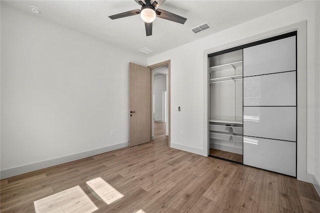 unfurnished bedroom with a closet, visible vents, light wood-style floors, ceiling fan, and baseboards