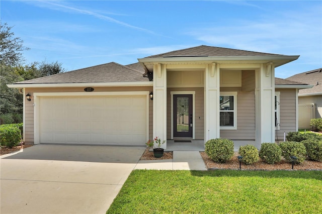 view of front of property featuring a front yard and a garage