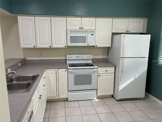 kitchen featuring white cabinetry, sink, light tile patterned floors, and white appliances