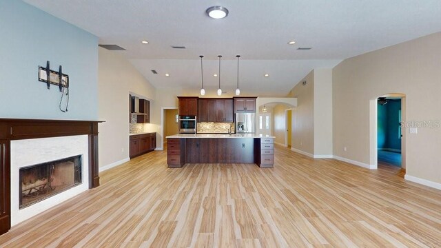 kitchen with a kitchen island, decorative light fixtures, stainless steel fridge with ice dispenser, and light hardwood / wood-style flooring