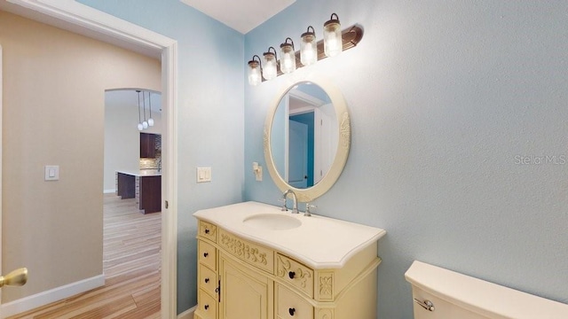 bathroom with wood-type flooring, vanity, and toilet