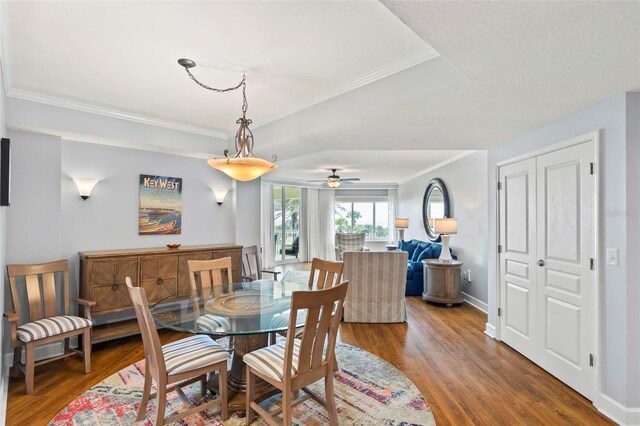 dining space with crown molding, dark hardwood / wood-style flooring, and ceiling fan