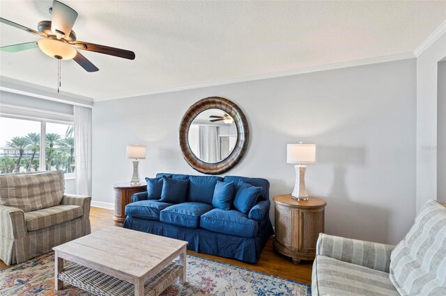 living room featuring light hardwood / wood-style flooring, ceiling fan, and ornamental molding