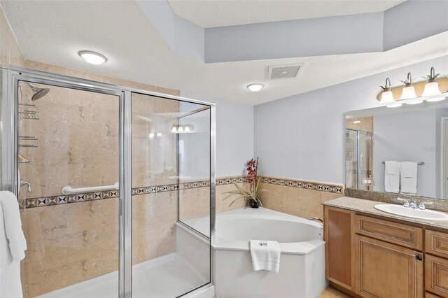 bathroom featuring vanity, plus walk in shower, and a textured ceiling