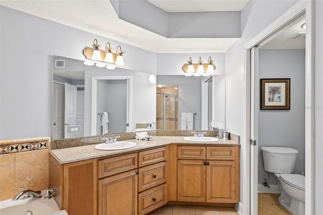 full bathroom with tile patterned floors, separate shower and tub, vanity, and toilet