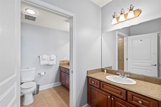 bathroom with tile patterned flooring, vanity, and toilet