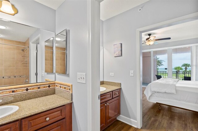 bathroom featuring ceiling fan, vanity, hardwood / wood-style floors, and tiled shower