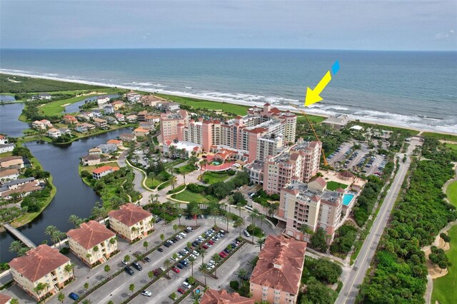 drone / aerial view with a water view and a beach view