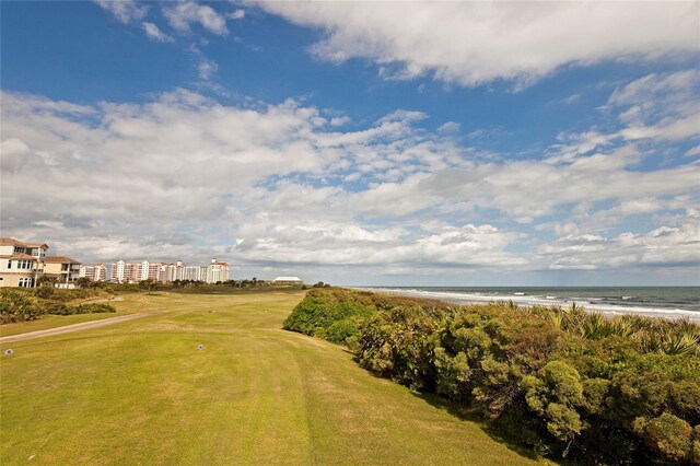 view of home's community with a view of the beach, a water view, and a lawn