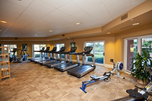 gym featuring carpet flooring and a paneled ceiling