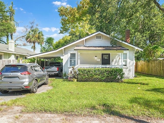 bungalow-style house featuring a carport, covered porch, and a front yard