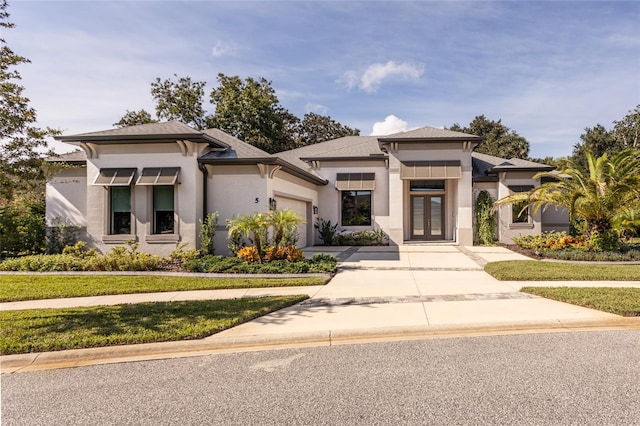 prairie-style home featuring a front yard and a garage